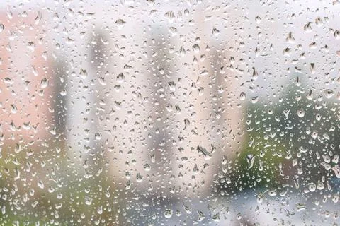 Iew of rain drops on window pane of urban house rainy weather in city - vi... Stock Photos