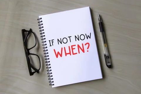 If not now when Text on a notepad with pen and calculator on a wooden table. Stock Photos