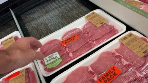 IGA retail grocery store man picks up pack of meat Stock Footage 158459376