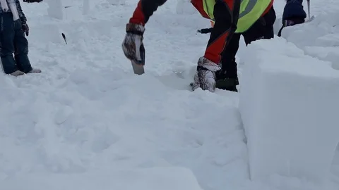 Igloo. A man cuts out a snow block with a hacksaw to build an Igloo. Close up. 스톡 동영상 124780972