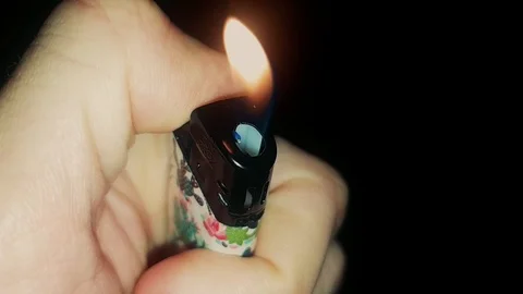 Ignite A Cigarette Lighter In The Hand On Black Background Stock Footage 122387689
