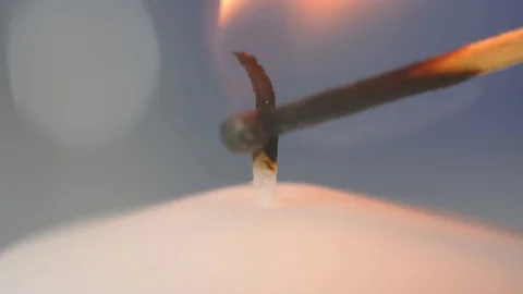 Ignites a match at a white candle with a match. Close-up of a burning candle. Stock Footage 123714205