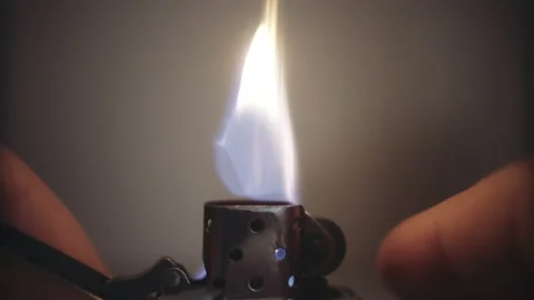 Igniting and talking gasoline lighter close up Video stock 153117611