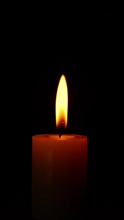 Igniting candle flame emerging in dark background Video stock 323857184