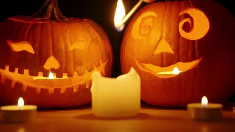 Igniting candle by halloween Jack-o'-lantern carved pumpkins in slow motion Stock Footage 278929111