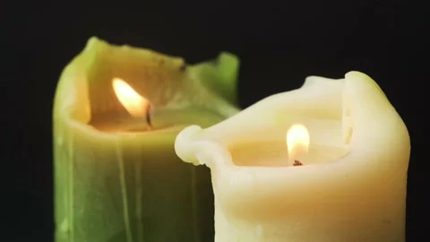 Igniting candles on black background closeup. Green and white natural wax candle Stock Footage 170498961