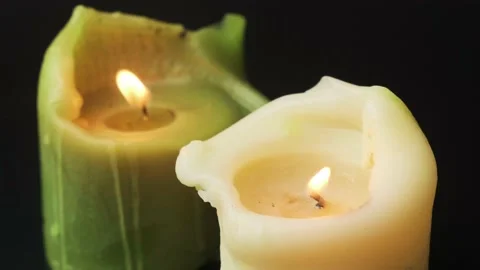 Igniting candles on black background closeup. Green and white natural wax candle Stock Footage 170499053