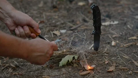 Igniting Fire with Ferro Rod and Striker Near Tactical Knife Stock Footage 342120410