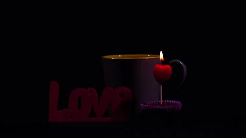 Igniting heart candle, a cup of tea and Love text Stock Footage 206024060