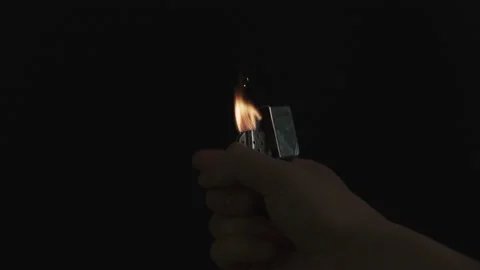 Igniting a lighter on a black background. Vídeos de archivo 134483874