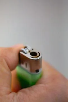 Igniting a lighter on a dark background. Stock Photos