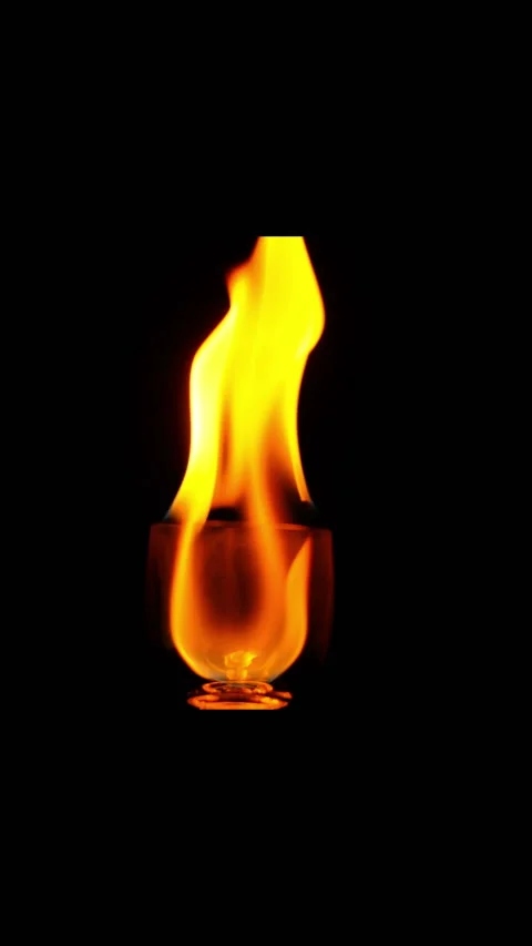 Ignition of flame in the wineglass on the black background in slow motion. verti Stock Footage 169849299