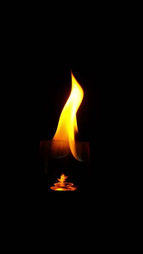 Ignition of flame in the wineglass on the black background in slow motion. verti Stock Footage 169849913