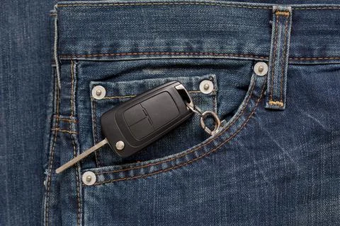 Ignition key is lying in side pocket of blue jeans. Stock Photos