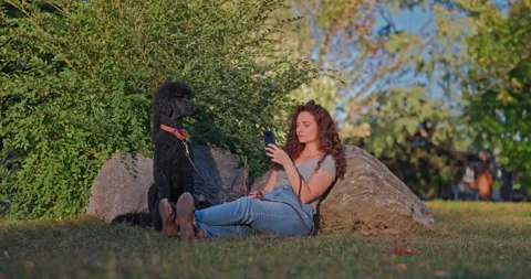 Ignoring Her Dog For Screen Time In The Park 库存影片 332825758