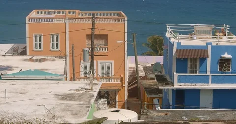 Iguana lizard crawls across the screen with colorful abandoned buildings in the Stock Footage 125112387