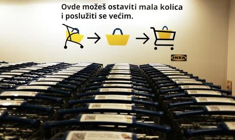 IKEA cart return zone with instruction sign in Serbian above rows of blue Photos
