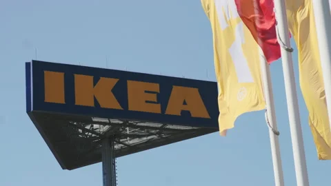 IKEA flags waving in the wind against sky and signboard, July 2022, Prague Stock Footage 203778631