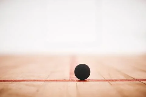 Ill be bouncing around in no time. a squash ball on the floor of a squash court. Stock Photos