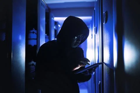 Ill crack into this system within seconds. a hacker using a digital tablet in a 스톡 사진
