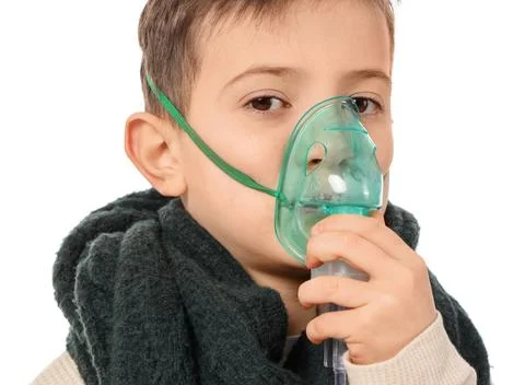 Ill little boy using nebulizer on white background, closeup Stock Photos