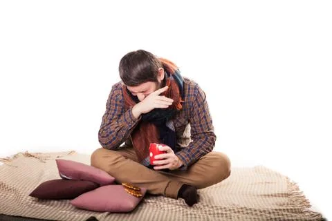 Ill man with flu drinking tea and coughing at home Stockfoto's