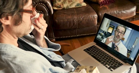 Ill man having a video chat with his doctor about his cold, flu, or allergies Stock Footage 120292458