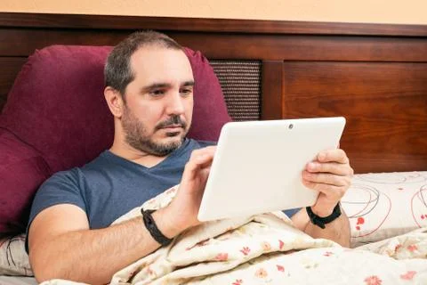 Ill man using tablet in the bed. Foto stock