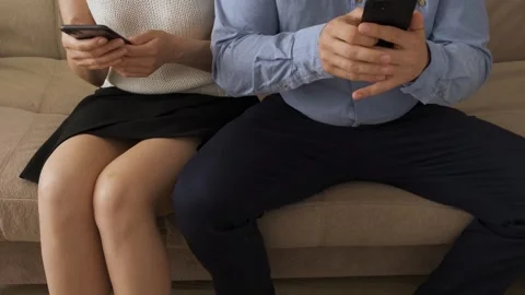 Ill-mannered man is sitting next to woman with legs spread wide and pushing her 스톡 동영상 243775727