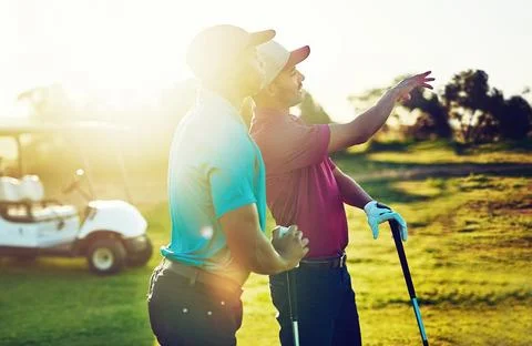Ill show you how to take it home. two friends playing a round of golf out on a Stock Photos