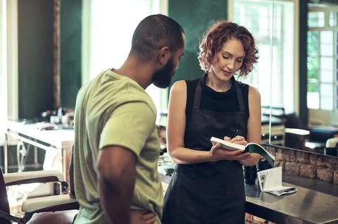 Ill write a receipt for you. a young hairdresser standing and writing a receipt Stock Photos