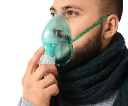 Ill young man using nebulizer on white background, closeup Stock Photos