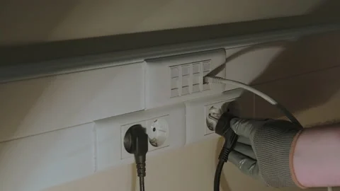 Illegal connection to the electrical network in the office, a gloved hand holds  Stock Footage 159885196