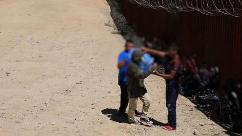 Illegal immigrant carrying pack of water on shoulder at Mexican border Stock Footage 109538048