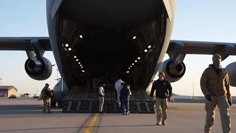 Illegal immigrants boarding C-17 Globemaster aircraft for deportation from USA Stock Footage 300261041