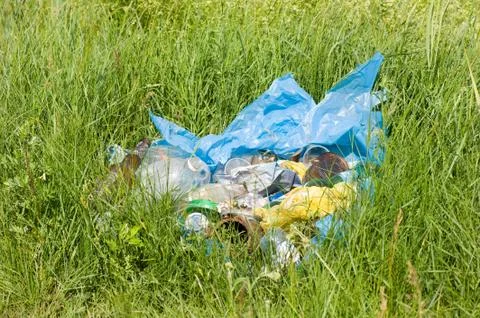 Illegal scatter garbage in blue plastic bag dump Stock Photos