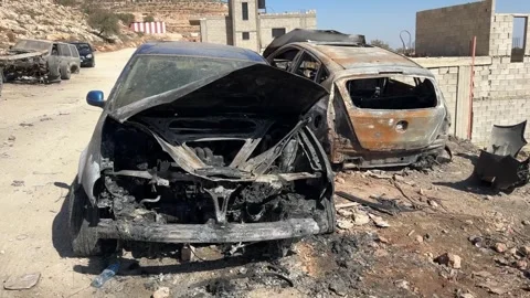 Illegal settlers torch Palestinian vehicles in West Bank village Stock Footage 320643723
