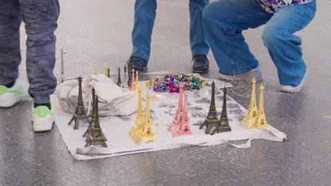 Illegal Street Vendor Selling Eiffel Tower Souvenirs On Ground In Paris, Medium Stock Footage 336475582