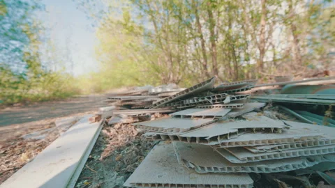 Illegally Dumped Plastic Wall Panels Stacked on Ground in Park | Waste Close-Up Stock Footage 334152468