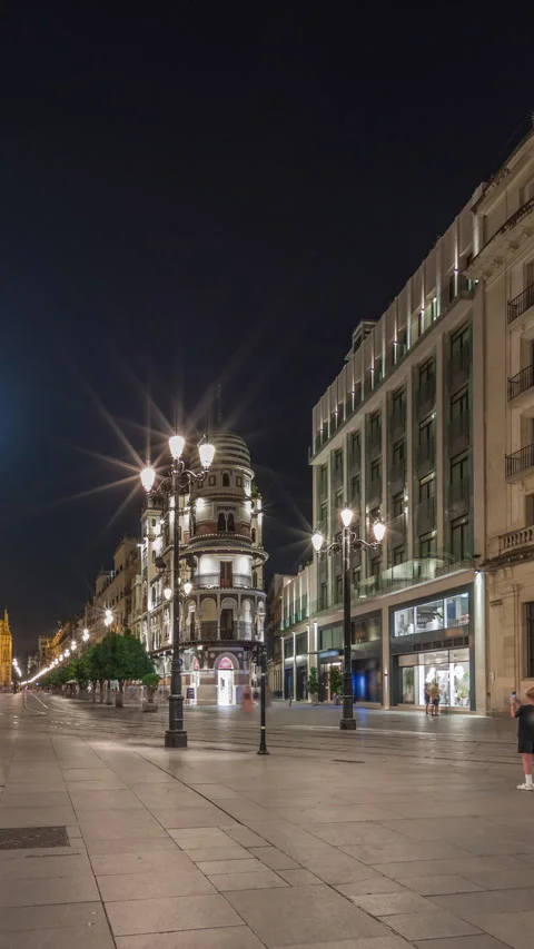 Illuminated Adriatica building on Avenida de la Constitucion at night, Seville Stock Footage 319894632