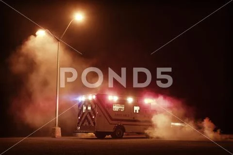 Illuminated ambulance on road at night Stock Photos