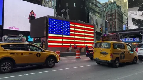 Illuminated American flag, digital billboards and car traffic in Times Square Stock Footage 237039341