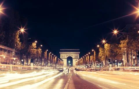 Illuminated Arc de Triomphe and the avenue Champs-Elysees in Paris. Famous Stock Photos