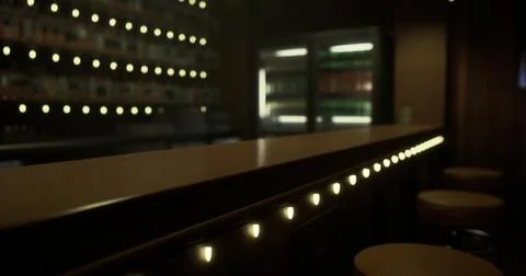 Illuminated bar interior showcasing subtle lighting and seating arrangements Stock Illustration
