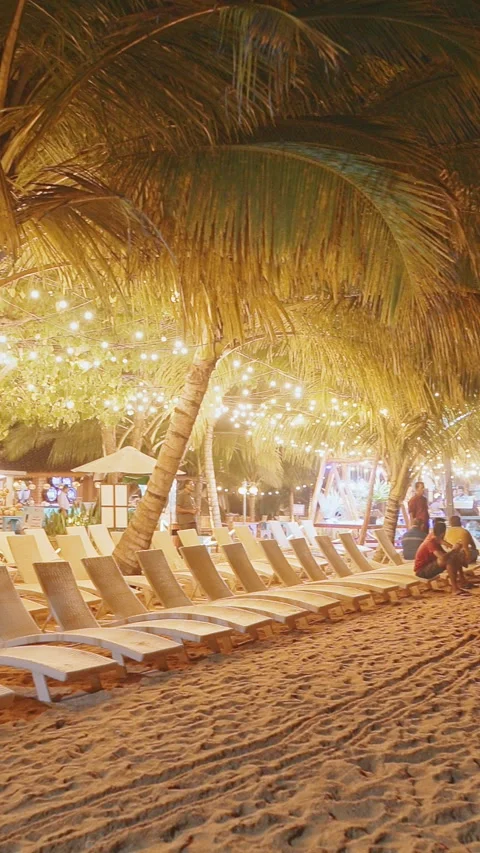 Illuminated Beach Chairs Under String Lights by the Shore Stockbeeldmateriaal 318391400