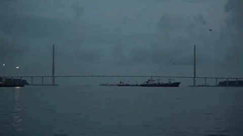 Illuminated bridge across strait. A lot of ships are anchored. View from water. Stock Footage 242545748