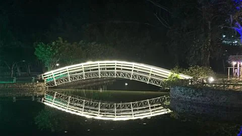 Illuminated bridge reflected in the lake. Stock Photos