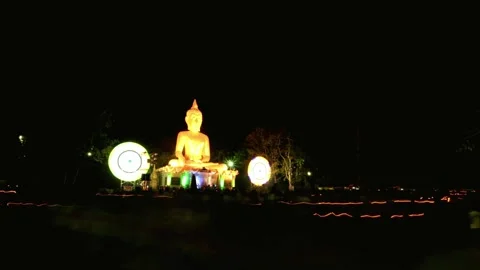 Illuminated Buddha Statue at Night with Devotees Gathering Stock Footage 310922864