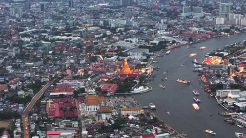 Illuminated Buddhist Wat Arun temple in the distance on Chao Phraya riverbank in Vídeos de archivo 307019092