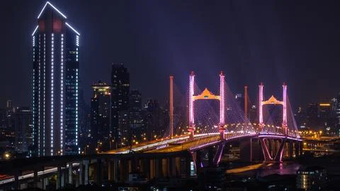 Illuminated Cable Stayed Bridge With Vibrant Purple Lights In Bangkok Night.. Foto stock